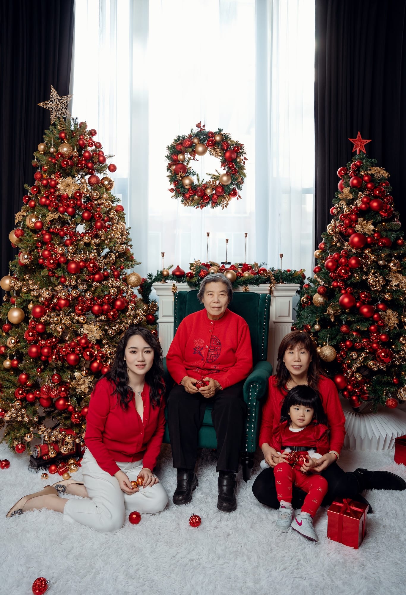 Family posing by a fireplace surrounded by Christmas trees