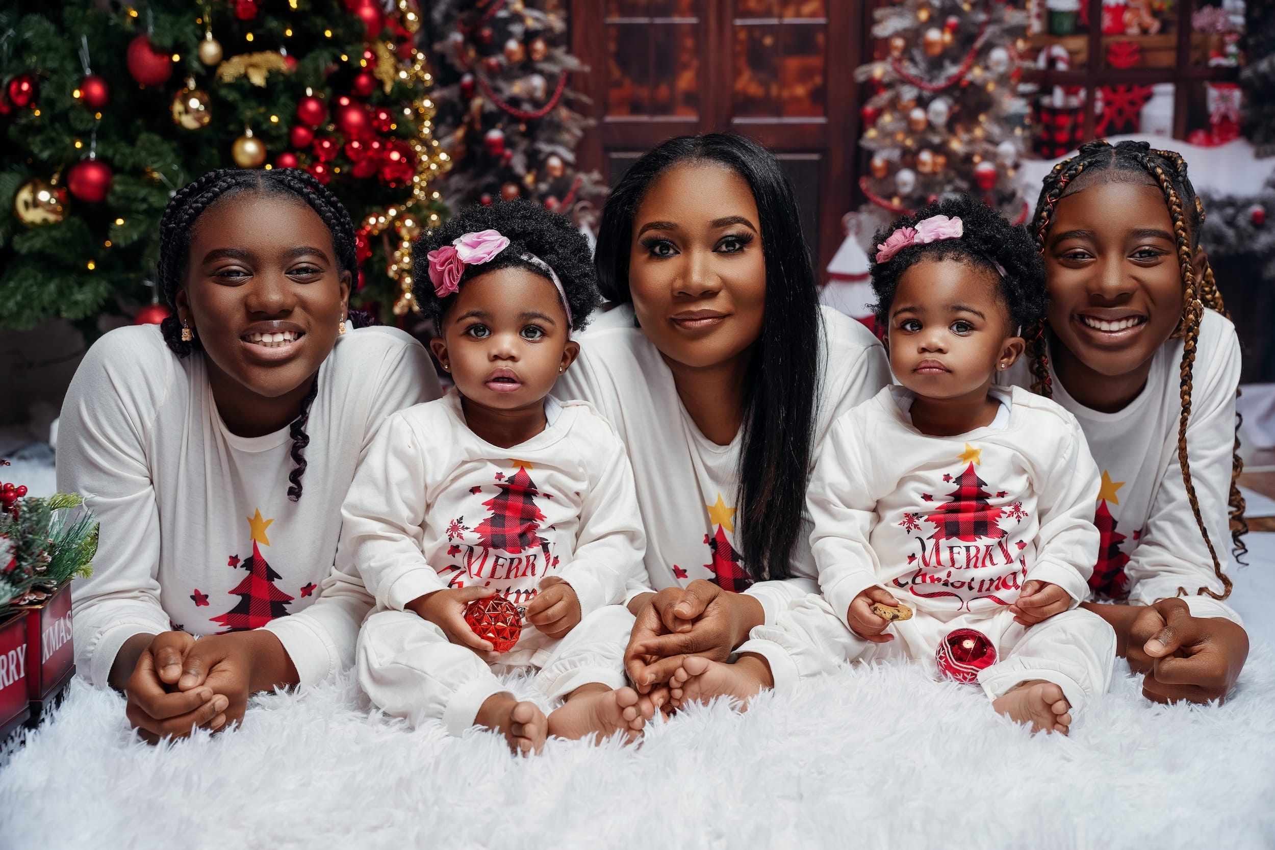 Big family in matching white Christmas pajamas on a fluffy rug